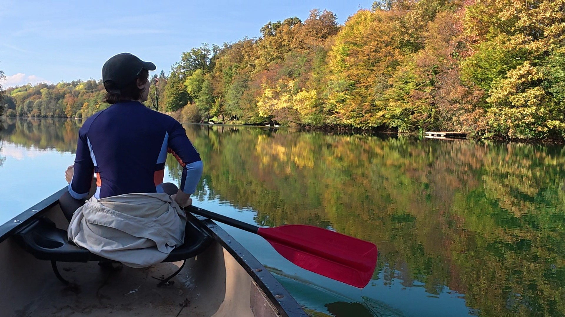 Viajero en canoa contemplando un lago en otoño